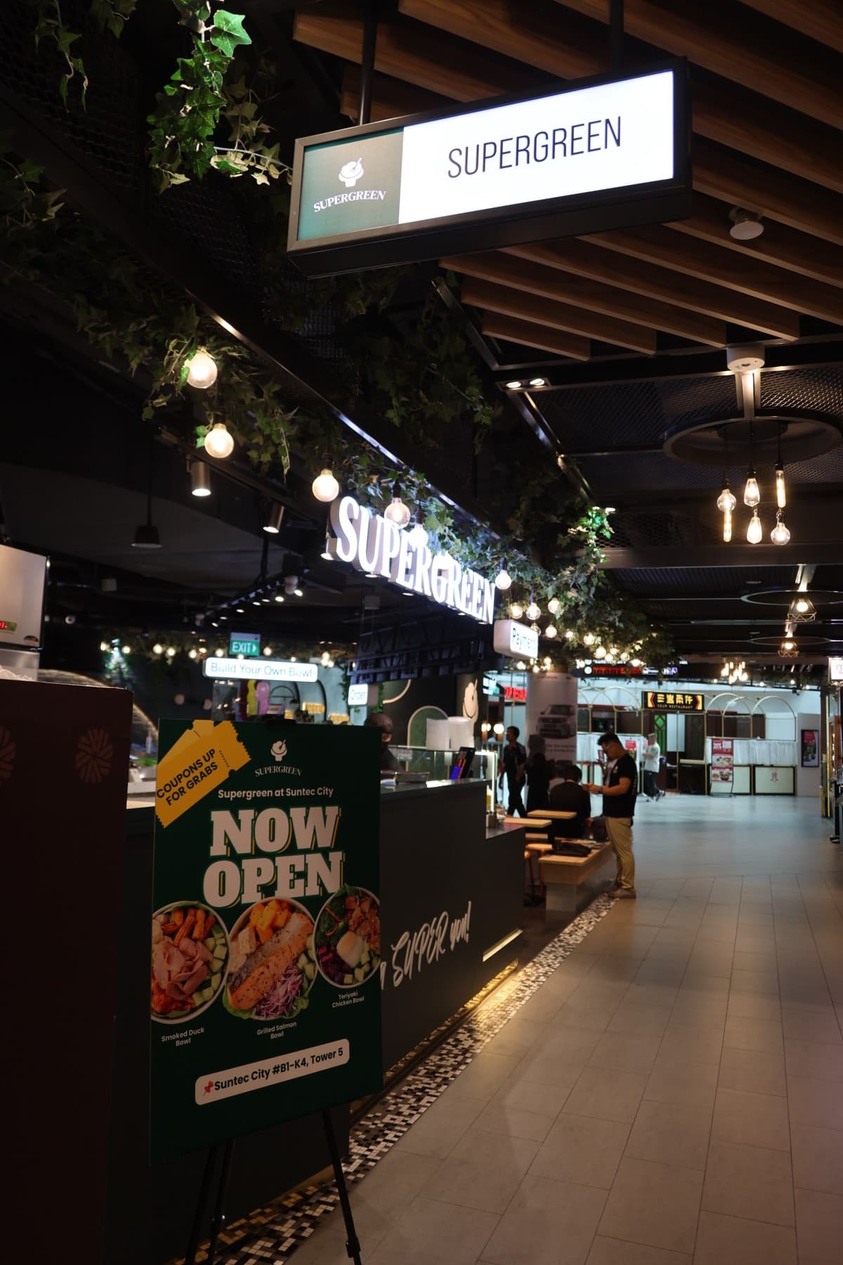 Protein options at the Supergreen counter, including Sichuan mala prawn, yakiniku beef, and roasted smoked duck